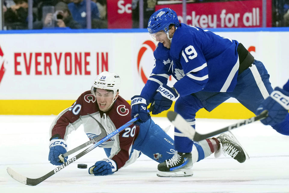 Colorado Avalanche center Ross Colton (20) vies for control of the puck with Toronto Maple Leafs center Calle Jarnkrok (19) during the first period of an NHL hockey game, Saturday, Jan. 13, 2024 in Toronto. (Chris Young/The Canadian Press via AP)