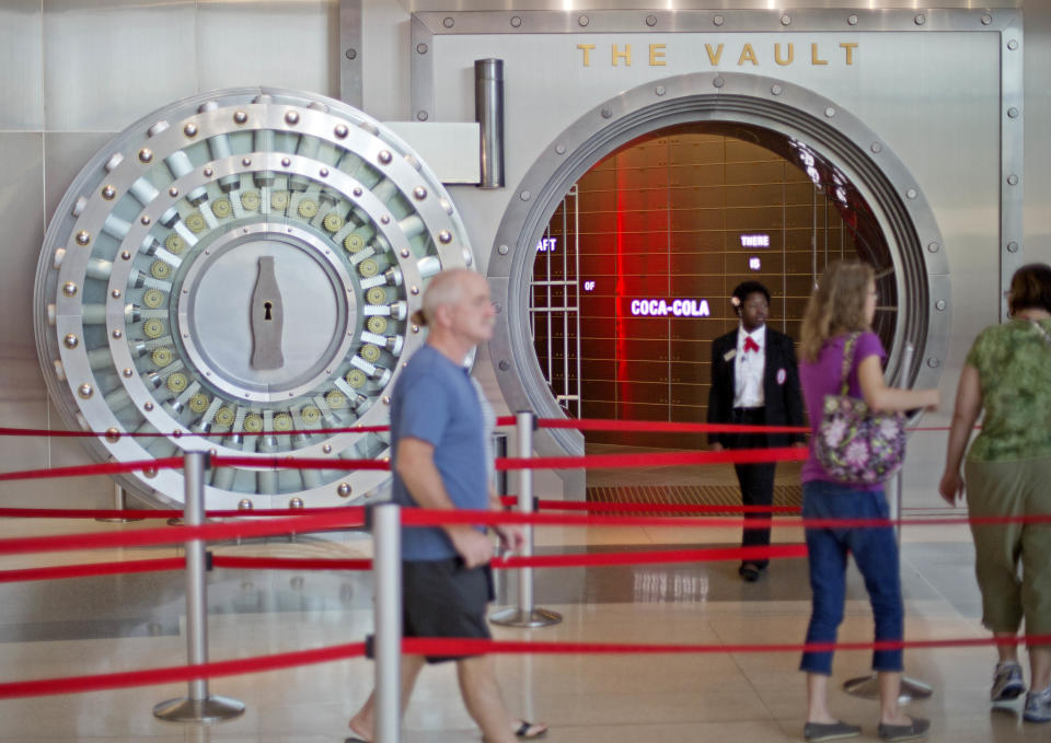 In this Friday, Aug. 9, 2013 photo, a tour group enters the vault exhibit containing the “secret recipe” for Coca-Cola at the World of Coca-Cola museum, in Atlanta. The 127-year-old recipe for Coke sits inside an imposing steel vault that’s bathed in red security lights, while security cameras monitor the area to make sure the fizzy formula stays a secret. (AP Photo/David Goldman)