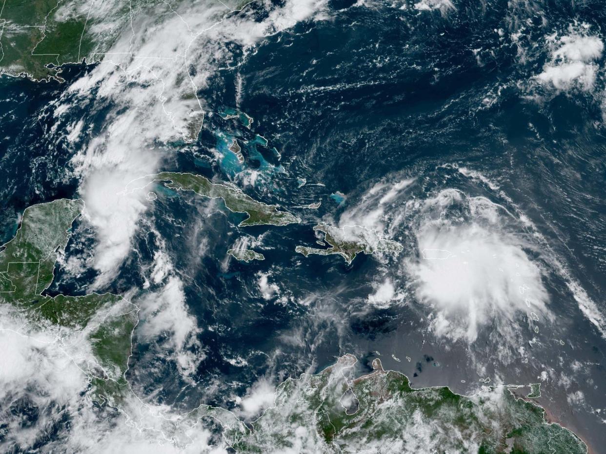 Tropical Storm Laura over Puerto Rico and approaching Haiti; and Tropical Storm Marco between Cuba and the Yucatan Peninsula: NOAA/GOES/AFP via Getty Images