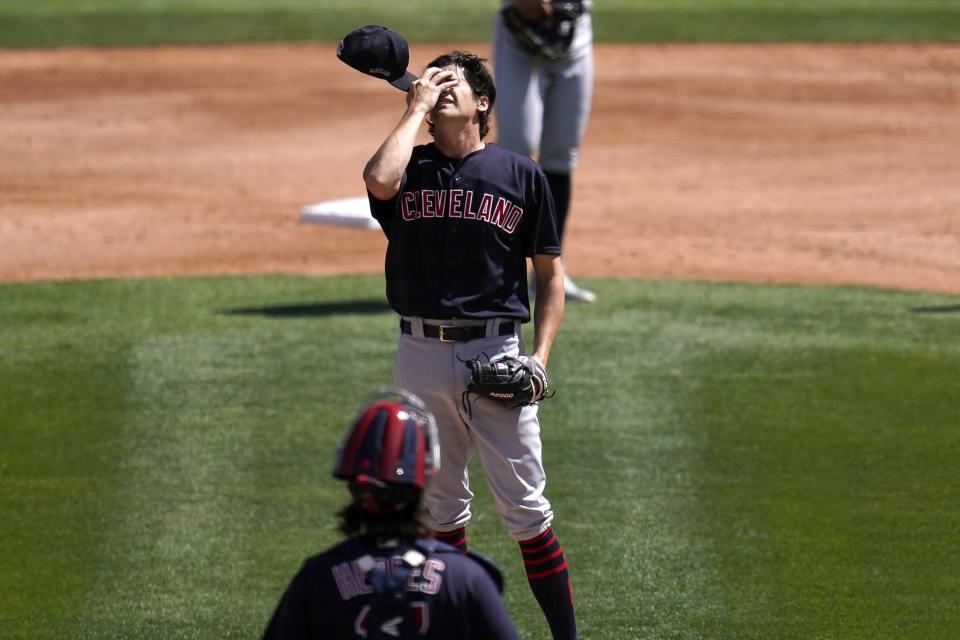 Cleveland Indians starting pitcher Cal Quantrill reacts after giving up three consecutive hits to the Chicago White Sox as Indians catcher Austin Hedges, bottom, arrives for a visit during the first inning of a spring training baseball game Saturday, March 20, 2021, in Phoenix. (AP Photo/Ross D. Franklin)