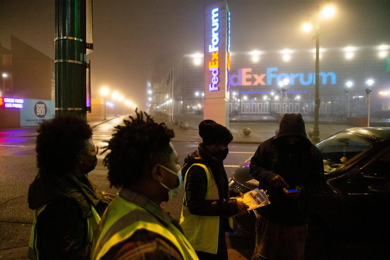 Andorian Thomas, Taurus Patton and Crystal Anthony, staff from Project for Assistance in Transition from Homelessness with CMI Healthcare Services, speak with an unhoused person in front of FedExForum at about 6 a.m. while taking part in the annual point-in-time count led by Community Alliance for the Homeless in Memphis, Tenn., on Thursday, January 25, 2024.