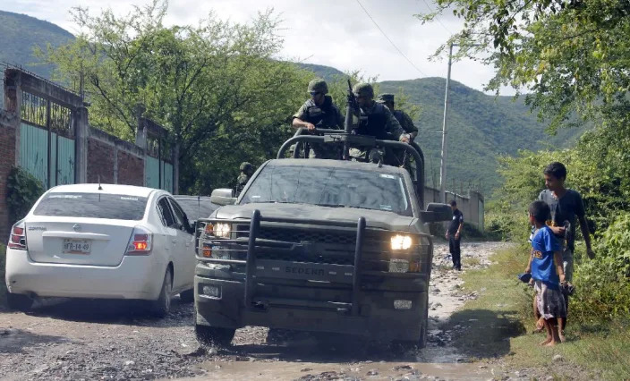 Mexican marines guard the site where a number of bodies were found in unmarked graves on the outskirts of Iguala, Guerrero state, on October 4,2014, the southern Mexico town where 43 students disappeared after a deadly police shooting last week (AFP Photo/Jesus Guerrero)