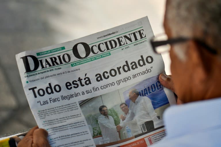 A man reads a newspaper in Cali, Colombia, on August 25, 2016 announcing that Colombian government and the Revolutionary Armed Forces of Colombia guerrillas signed in Havana a historic and definitive agreement to end a half century of armed conflict