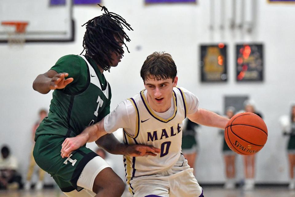 Male’s Cole Edelen (0)drives past Trinity's Lance Chandler (1) during the second half of their game at Male High School, Friday, Dec., 1, 2023 in Louisville Ky. Male won 62-55.