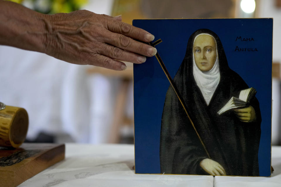 A devotee touches a painting depicting María Antonia de Paz y Figueroa, more commonly known by her Quechua name of “Mama Antula,” on the outskirts of Buenos Aires, Argentina, Sunday, Jan. 28, 2024. The canonization of “Mama Antula” in a Feb. 11th ceremony to be presided by Pope Francis at St. Peter's Basilica marks the first time a female from Argentina will become saint. (AP Photo/Natacha Pisarenko)