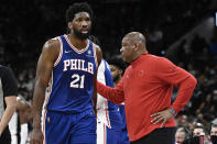 Philadelphia 76ers head coach Doc Rivers, right, pats Philadelphia forward Joel Embiid on the back as Embiid walks to the bench during the first half of an NBA basketball game against the San Antonio Spurs, Sunday, Jan. 23, 2022, in San Antonio. (AP Photo/Darren Abate)