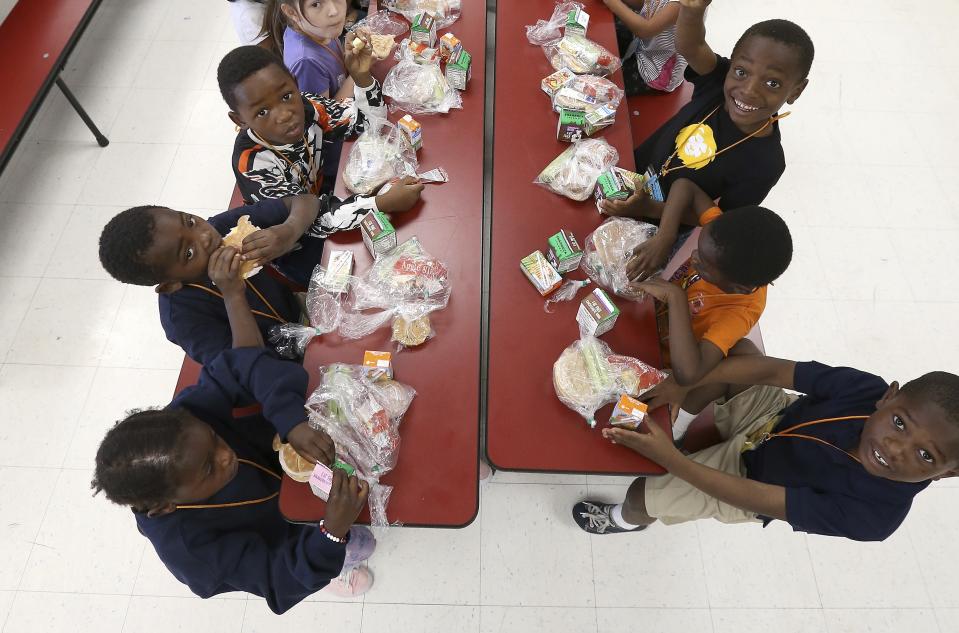 Students eat lunch in the cafeteria at Valencia Newcomer School Thursday, Oct. 17, 2019, in Phoenix. Children from around the world are learning the English skills and American classroom customs they need to succeed at so-called newcomer schools. Valencia Newcomer School in Phoenix is among a handful of such public schools in the United States dedicated exclusively to helping some of the thousands of children who arrive in the country annually. (AP Photo/Ross D. Franklin)