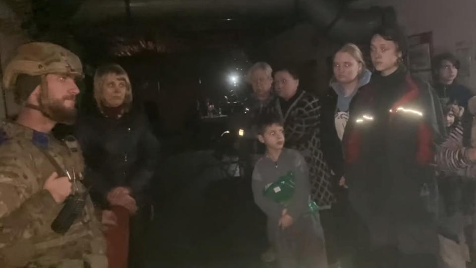 A Ukrainian soldier and civilians on Sunday in darkness inside the Azovstal steel plant in Mariupol, Ukraine.