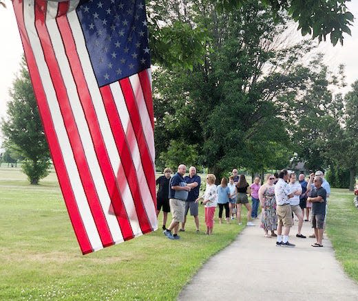 An American flag flies over the walking path at Fairbury's North Park during a dedication event in honor of the late Lynn Dameron.
