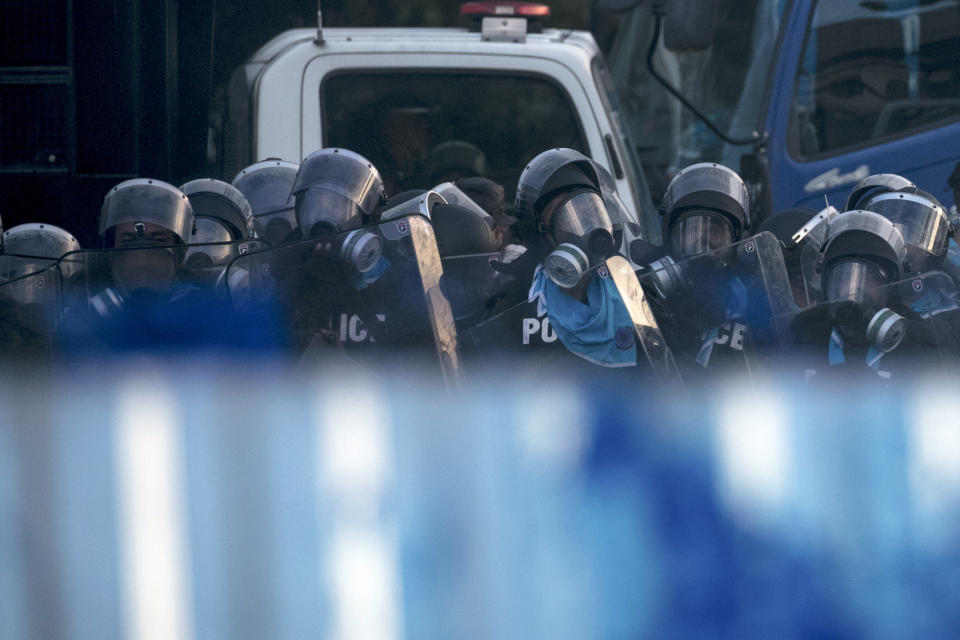 Police in riot gear stand in formation to disperse pro-democracy demonstrators near the Parliament in Bangkok, Tuesday, Nov. 17, 2020. Thailand's political battleground shifted to the country's Parliament Tuesday, where lawmakers are considering proposals to amend the country's constitution, one of the core demands of the student-led pro-democracy movement. (AP Photo/Wason Wanichakorn)