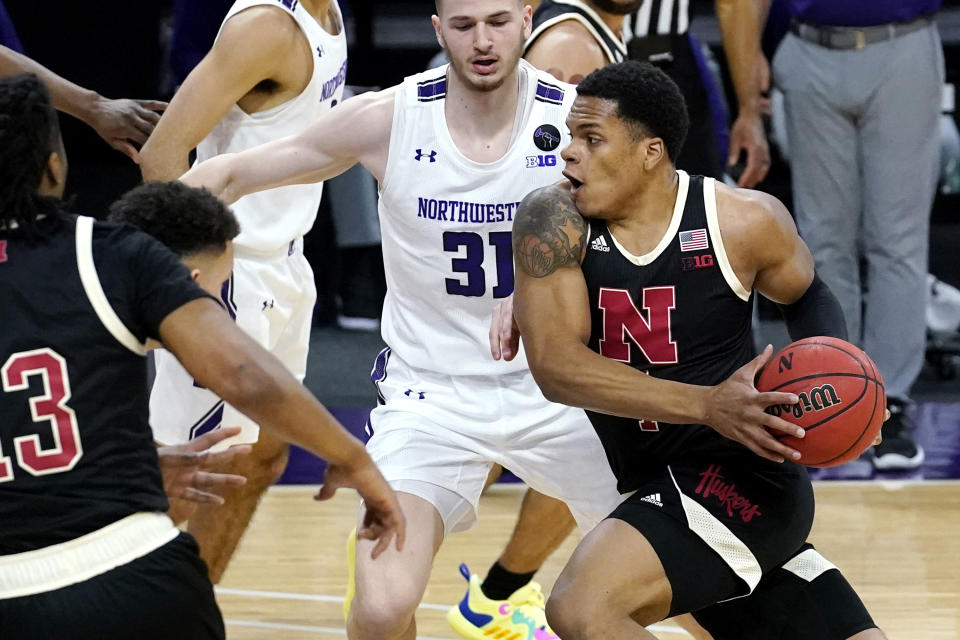 Nebraska guard Shamiel Stevenson, right, drives against Northwestern forward Pete Nance, left, and forward Robbie Beran, center, during the first half of an NCAA college basketball game in Evanston, Ill., Sunday, March 7, 2021. (AP Photo/Nam Y. Huh)