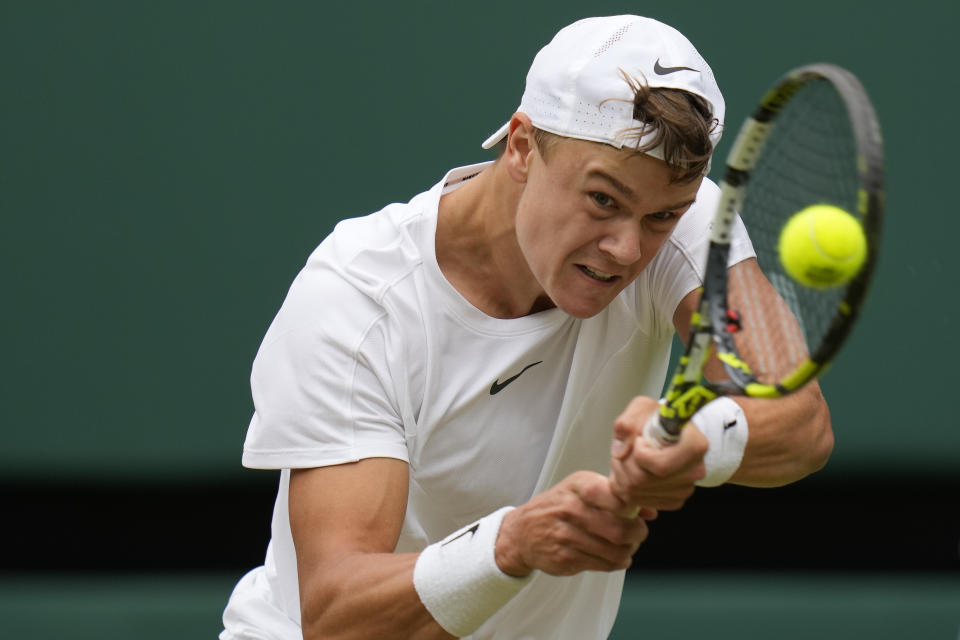 FILE - Denmark's Holger Rune returns to Carlos Alcaraz in a men's singles match on day ten of the Wimbledon tennis championships in London, Wednesday, July 12, 2023. Rune is one of the men to watch at the U.S. Open, which begins at Flushing Meadows on Aug. 28.(AP Photo/Kirsty Wigglesworth, File)