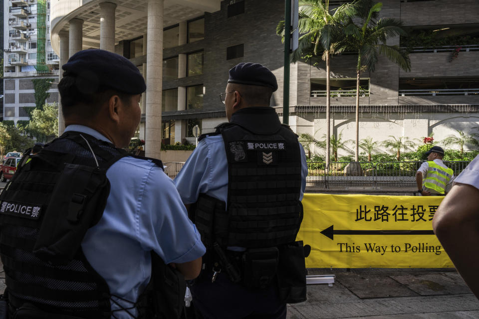 Police officers patrol outside a polling station during the District Council elections in Hong Kong, Sunday, Dec. 10, 2023. Residents went to the polls on Sunday in Hong Kong's first district council elections since an electoral overhaul was implemented under Beijing's guidance of “patriots” administering the city, effectively shutting out all pro-democracy candidates.(AP Photo/Louise Delmotte)