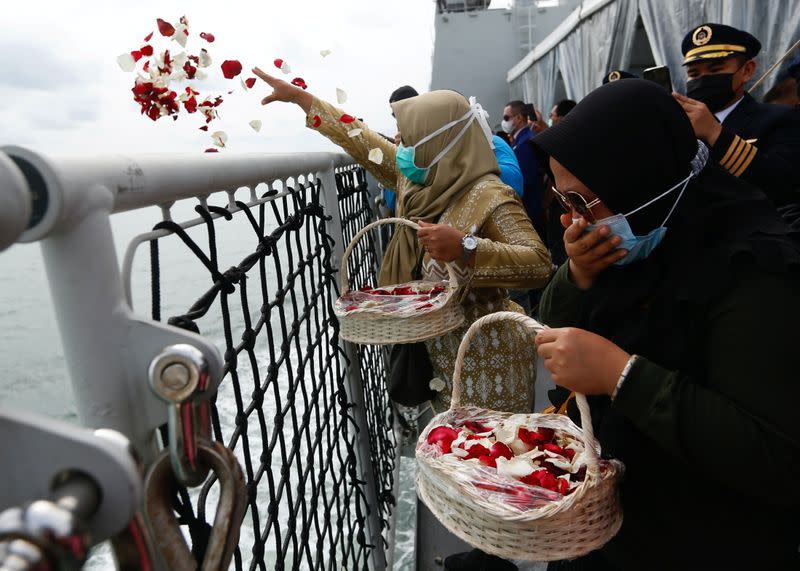 Family members of the passengers of Sriwijaya Air flight SJ 182, which crashed into the sea, react while throwing flowers and petals from the deck of Indonesia's Naval ship KRI Semarang as they visit the site of the crash to pay their tribute