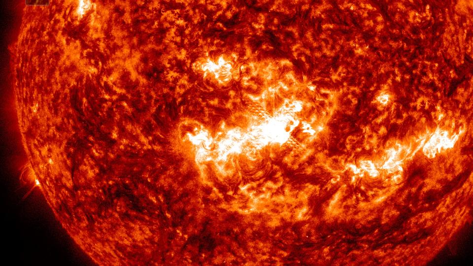  A bright white flare erupts from the fiery surface of the sun. 