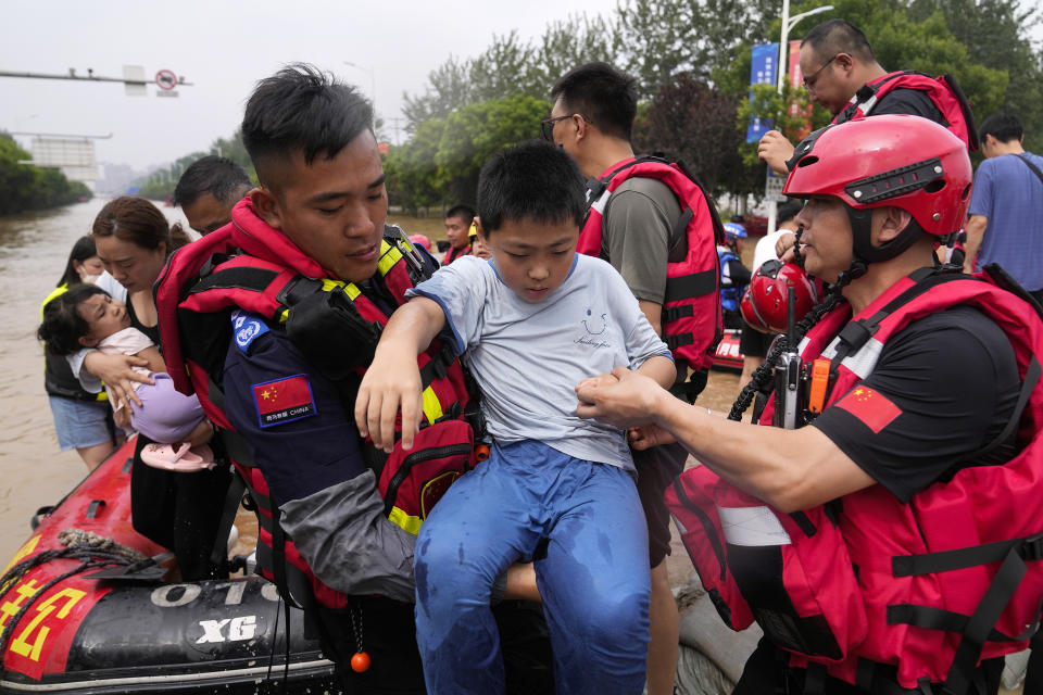 Rescuers using rubber boats evacuate trapped residents through floodwaters in Zhuozhou in northern China's Hebei province, south of Beijing, Wednesday, Aug. 2, 2023. China's capital has recorded its heaviest rainfall in at least 140 years over the past few days. Among the hardest hit areas is Zhuozhou, a small city that borders Beijing's southwest. (AP Photo/Andy Wong)