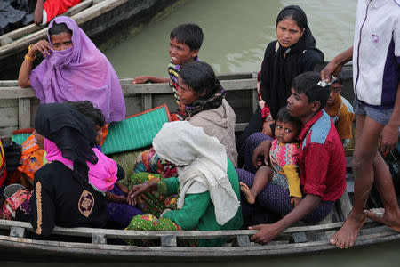 Rohingya refugees who arrived from Myanmar last night by boat, get into another boat to go to the mainland, in Teknaf, Bangladesh October 7, 2017. REUTERS/Mohammad Ponir Hossain