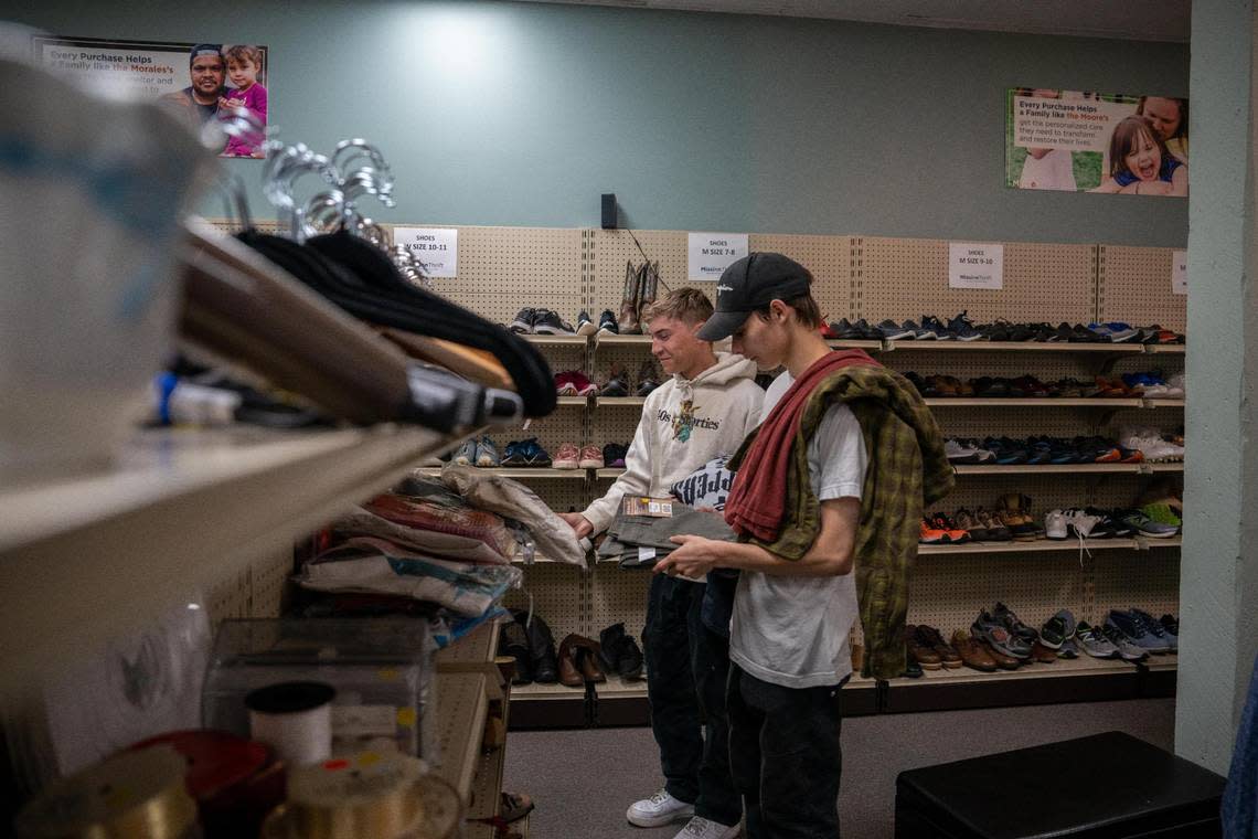 Joseph Peranzi and David Vincent look through the many clothes options at Mission Thrift in Tacoma Wash. on Thursday July 4, 2022.