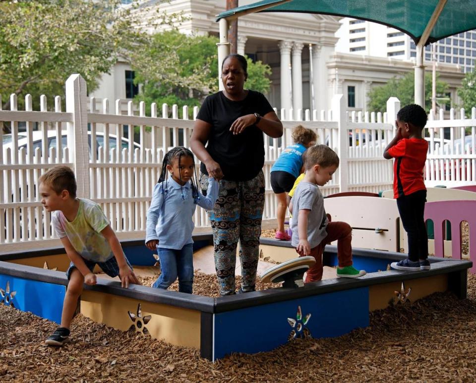 Preschool teacher Tiffany Isaac watches children on the playground at the Rosie K. Mauk Child Development Center in Fort Worth on Wednesday.