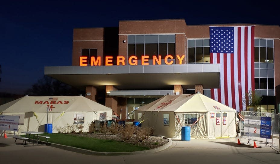 The McDonough District Hospital Emergency entrance is seen at night with tents nearby in April, 2020, shortly after the outset of the COVID-19 pandemic.
