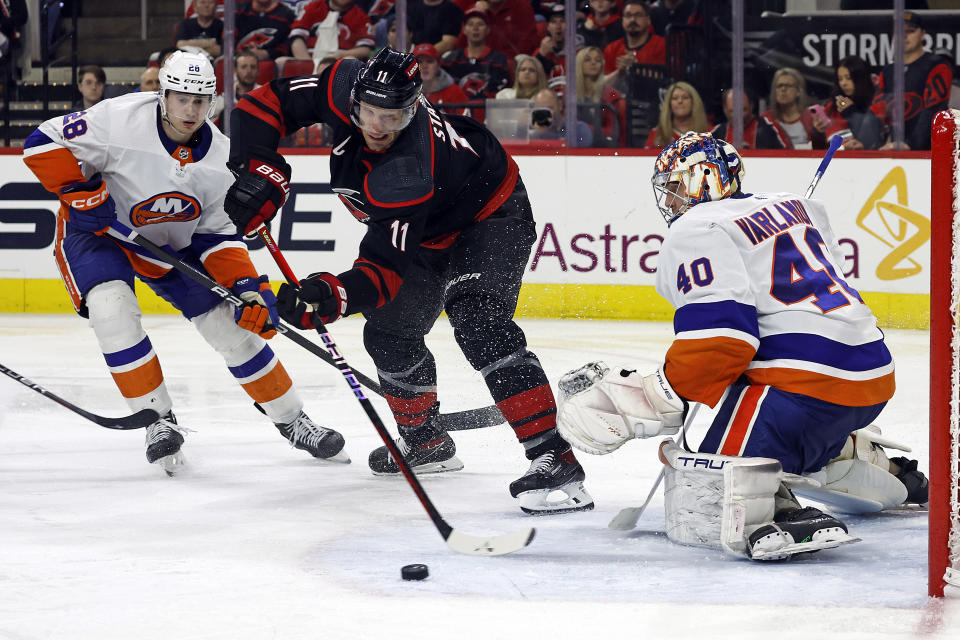 Carolina Hurricanes' Jordan Staal (11) controls the puck in front of New York Islanders goaltender Semyon Varlamov (40) with Islanders Alexander Romanov (28) nearby during the second period in Game 1 of an NHL hockey Stanley Cup first-round playoff series in Raleigh, N.C., Saturday, April 20, 2024. (AP Photo/Karl B DeBlaker)