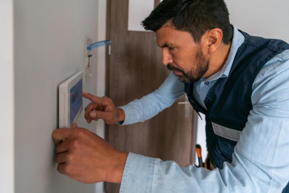 A man sets up a home security system.