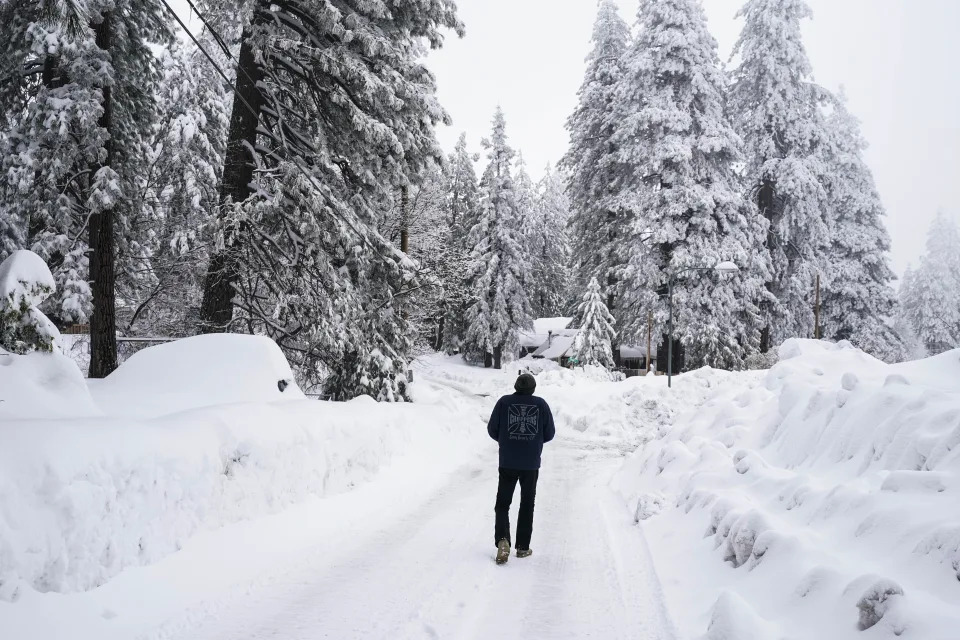 A local resident who declined to give his name walks to his home in Running Springs, Calif., Tuesday, Feb. 28, 2023. Tremendous rains and snowfall since late last year have freed half of California from drought, but low groundwater levels remain a persistent problem, U.S. Drought Monitor data showed Thursday, March 2. (AP Photo/Jae C. Hong)