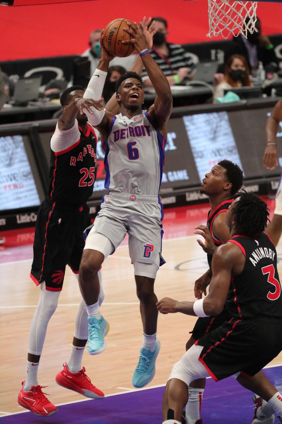 Pistons guard Hamidou Diallo scores against Raptors forward Chris Boucher on Monday, March 29, 2021 at Little Caesars Arena.