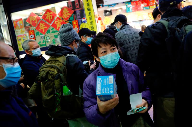 FILE PHOTO: Customers queue to buy face masks to protect from a new coronavirus outbreak in Hong Kong