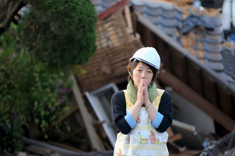 A woman reacts in front of collapsed house caused by an earthquake in Mashiki town, Kumamoto prefecture, southern Japan, in this photo taken by Kyodo April 16, 2016. Mandatory credit REUTERS/Kyodo