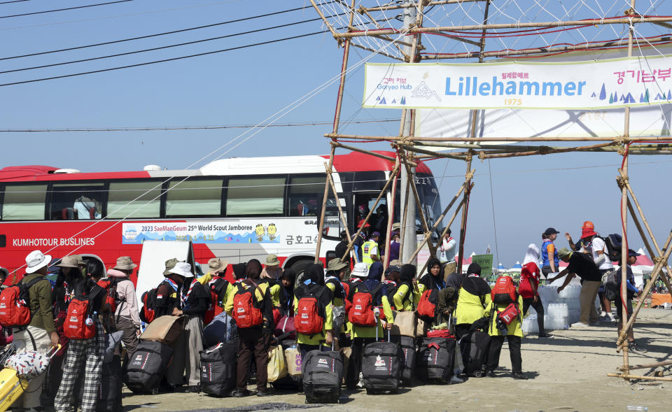 Attendees of the World Scout Jamboree get on a bus to leave a scout camping site in Buan, South Korea, Tuesday, Aug. 8, 2023. Buses began moving thousands of global Scouts from their campsite on South Korea's coast to inland venues Tuesday ahead of a tropical storm that is forecast to bring intense rains and strong winds to the peninsula within days. (Na Bo-bae/Yonhap via AP)