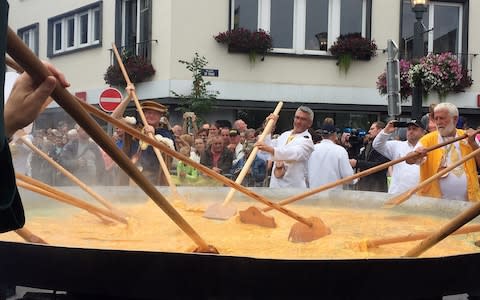 Cooks and volunteers stir eggs on an oversize pan at the 22nd Giant Omelet event in Malmedy, Belgium, Tuesday, Aug. 15, 2017 - Credit: AP