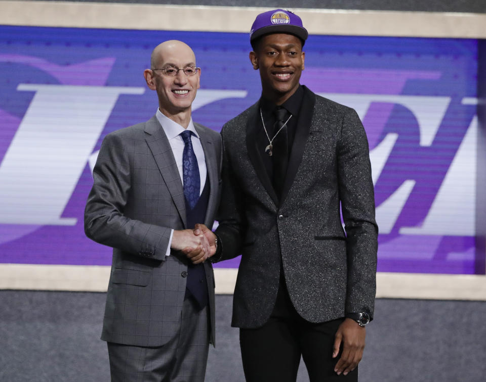 FILE - In this Thursday, June 20, 2019, file photo, Virginia's De'Andre Hunter, right, is greeted by NBA Commissioner Adam Silver after being selected with the fourth pick overall by the Los Angeles Lakers during the NBA basketball draft in New York. Hunter went No. 4 overall, taken by the Los Angeles Lakers. His rights had been traded twice, first to New Orleans as part of the Anthony Davis deal, then to Atlanta. But since neither of those trades could be closed before July 6, Hunter wore a Lakers cap on stage. Silver wants the hat game fixed. (AP Photo/Julio Cortez, File)