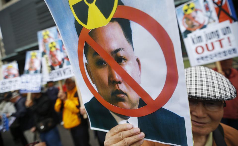 Protesters from a right-wing, conservative and anti-North Korean civic group hold banners depicting North Korean leader Kim Jong Un during an anti-North Korean rally on the 102th birthday of North Korean founder Kim Il Sung in central Seoul