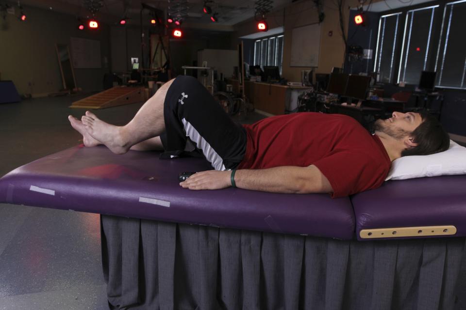 Kent Stephenson lies down during voluntary training while Katelyn Gurley (not seen) tracks his level of muscle activity and force at the Human Locomotion Research Center laboratory, Frazier Rehab Institute, as part of the University of Louisville's Kentucky Spinal Cord Injury Research Center in Louisville, Kentucky, as pictured in this handout photo courtesy of University of Louisville. Four men, who had each been paralyzed from the chest down for more than two years and been told their situation was hopeless, regained the ability to voluntarily move their legs and feet - though not to walk - after an electrical device was implanted in their spines, researchers reported on April 8, 2014. To match story SCIENCE-PARALYZED/ REUTERS/University of Louisville/Handout via Reuters (UNITED STATES - Tags: HEALTH SCIENCE TECHNOLOGY SOCIETY) ATTENTION EDITORS - THIS PICTURE WAS PROVIDED BY A THIRD PARTY. REUTERS IS UNABLE TO INDEPENDENTLY VERIFY THE AUTHENTICITY, CONTENT, LOCATION OR DATE OF THIS IMAGE. THIS PICTURE IS DISTRIBUTED EXACTLY AS RECEIVED BY REUTERS, AS A SERVICE TO CLIENTS. NO SALES. NO ARCHIVES. FOR EDITORIAL USE ONLY. NOT FOR SALE FOR MARKETING OR ADVERTISING CAMPAIGNS