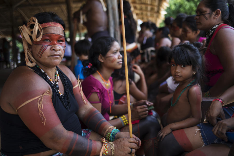 In this Sept. 3, 2019 photo, indigenous Tembé eomen listen to speakers during a meeting of tribes at the Tekohaw indigenous reserve, Para state, Brazil. President Jair Bolsonaro has argued that such large reserves have hindered Brazil’s economic interests. But the indigenous people of Latin America’s largest economy have everything at stake. (AP Photo/Rodrigo Abd)