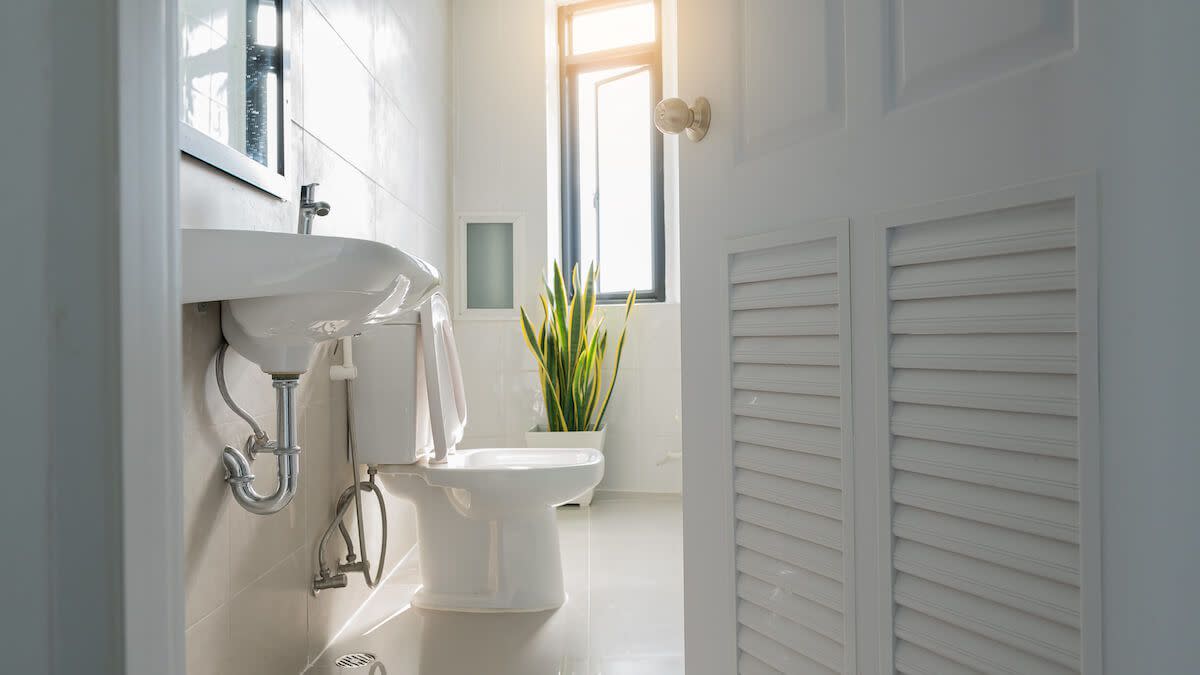 A view of a toilet in a bathroom from the side