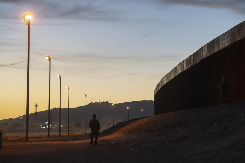 Personas alineadas junto al muro fronterizo tras cruzar a Estados Unidos desde México son detenidas por la Patrulla Fronteriza en El Paso, Texas, el 8 de mayo de 2023.  (Todd Heisler/The New York Times)