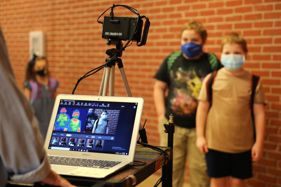 Corinth Elementary School students have their temperature checked by a thermal scanner as they arrive for their first day back to school  July 27 in Corinth, Miss.