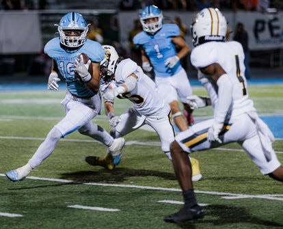 Bartlesville High tailback P.J. Wallace, left, turns a corner during a mid-season game in the 2022 campaign.