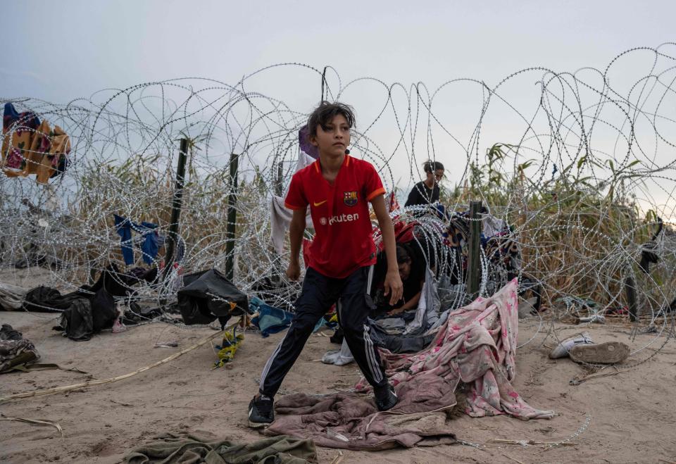 Chelsea from Nicaragua looks on after crawling through a hole made in the razor wire to cross into Eagle Pass, Texas. Dozens of migrants arrived at the US-Mexico border on Sept. 22, 2023, hoping to be allowed into the United States.