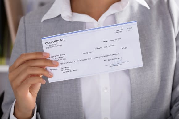 Woman with paycheck in her hand