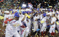 In this Feb. 10, 2019 photo, Panama's Los Toros de Herrera baseball players celebrate their 3-0 victory over Cuba's Los Leneros de las Tunas amid confetti at the end of the Caribbean Series baseball tournament's final, championship game at Rod Carew stadium in Panama City. (AP Photo/Arnulfo Franco)