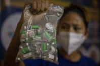 An Indian health worker shows empty vials of COVID-19 vaccine in Gauhati, India, Thursday, Oct. 21, 2021. India has administered 1 billion doses of COVID-19 vaccine, passing a milestone for the South Asian country where the delta variant fueled its first crushing surge this year. (AP Photo/Anupam Nath)