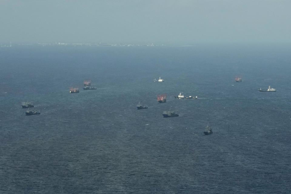 Suspected Chinese militia boats stay close to Chinese-built Subi island on Friday, Dec. 1, 2023 at the disputed South China Sea. The Philippine coast guard inaugurated a new monitoring base Friday on a remote island occupied by Filipino forces in the disputed South China Sea as Manila ramps up efforts to counter China's increasingly aggressive actions in the strategic waterway. (AP Photo/Aaron Favila)