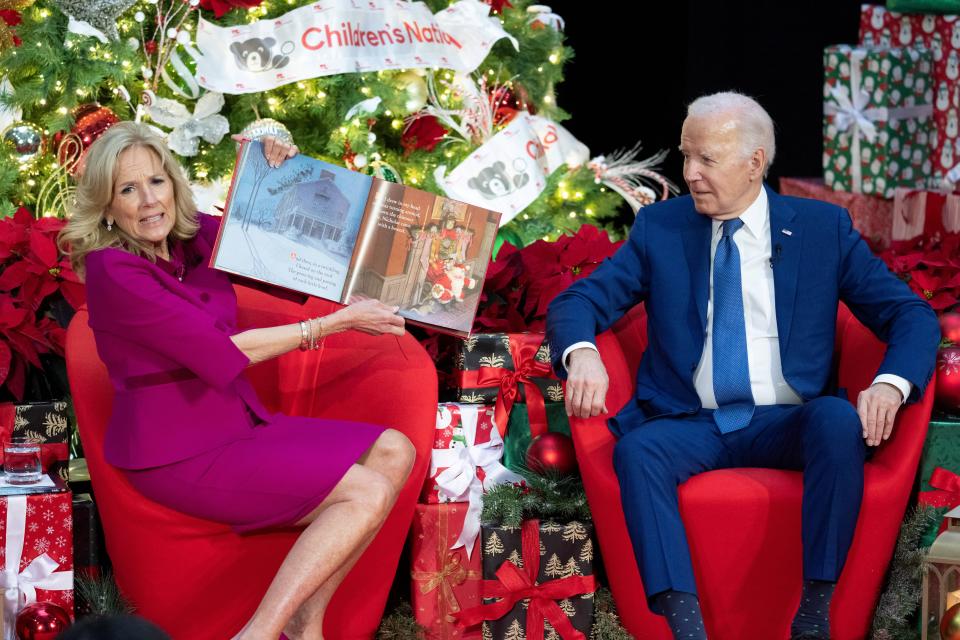 President Joe Biden sits next to first lady Jill Biden as she reads "'Twas the Night Before Christmas" during a holiday visit to patients and families at Children's National Hospital in Washington, D.C., on Dec. 22.