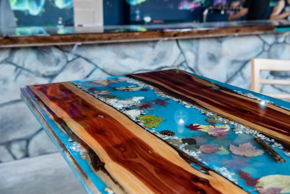 Tables at Mystic Ways Brewing Co. in Perkasie feature handcrafted river tables made with live edge wood and epoxy resin, embedded with nature-inspired elements throughout.