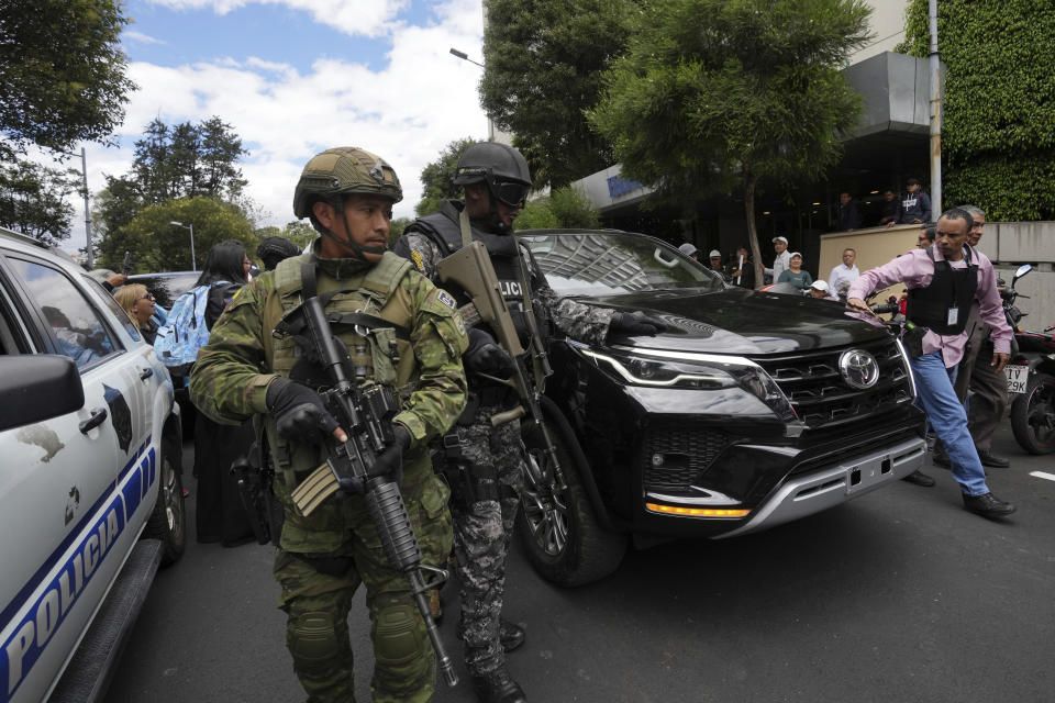 Fuerzas de seguridad custodian el vehículo en el que se desplaza la aspirante presidencial Luisa González, del Movimiento Revolución Ciudadana, a su salida de la Fiscalía General, adonde presentó una denuncia por un presunto plan para matarla en Quito, Ecuador, el lunes 18 de septiembre de 2023. Los ecuatorianos irán a segunda vuelta presidencial el 15 de octubre, tras el asesinato de uno de los candidatos presidenciales. (AP Foto/Dolores Ochoa)