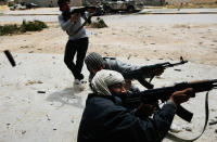 <p>Rebel fighters fire at government loyalist troops during street fighting on Tripoli Street in downtown Misurata April 20, 2011 in Misrata, Libya. Rebel forces assaulted the downtown positions of troops loyal to Libyan strongman Moammar Gaddafi April 20, briefly forcing them back over a key bridge and trapping several in a building that rebel troops then surrounded. (Photo by Chris Hondros/Getty Images) </p>