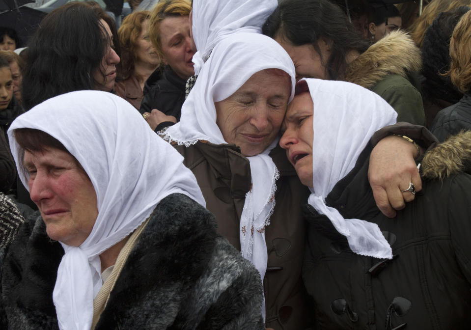 Ethnic Albanian woman weep during the funeral ceremony of 19 ethnic Albanians killed during the 1998-99 Kosovo war in the town of Mala Krusa on Wednesday, March 26, 2014. The victims were killed in two separate rampages by Serbs forces in the town of Suva Reka and Mala Krusa just days after NATO began a bombing campaign to end an onslaught by Serbia on separatist ethnic Albanians. (AP Photo/Visar Kryeziu)